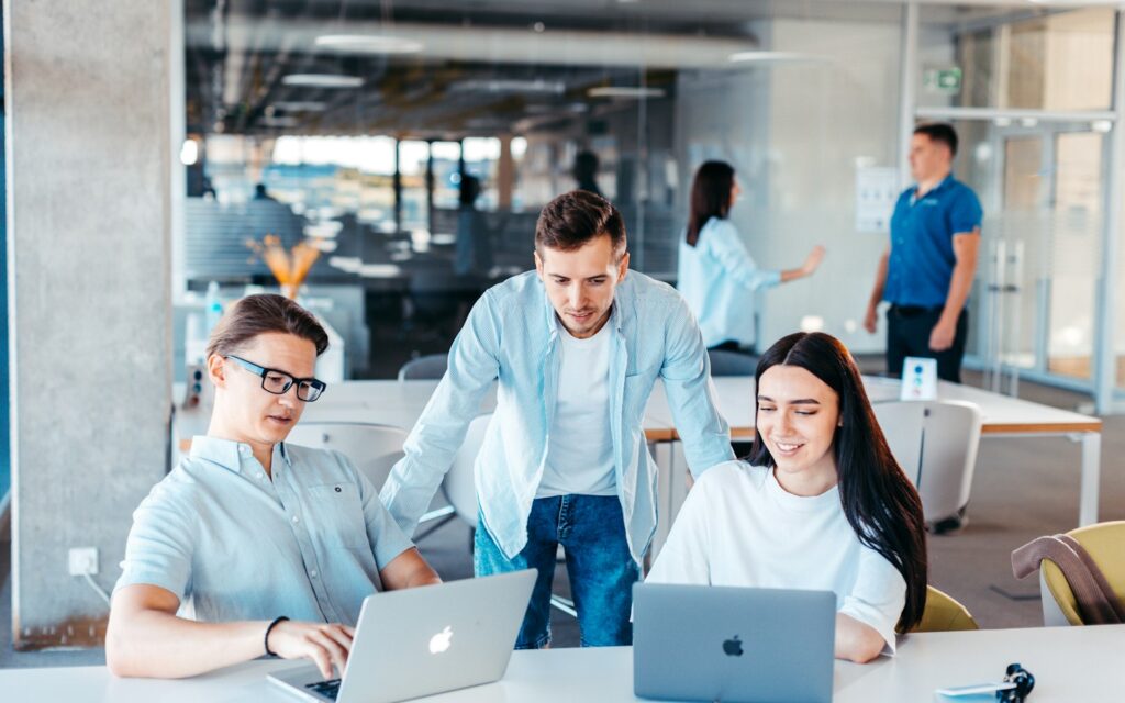 Junge Kolleginnen und Kollegen im Gespräch am Konferenztisch, Employer Branding durch Teamkultur
