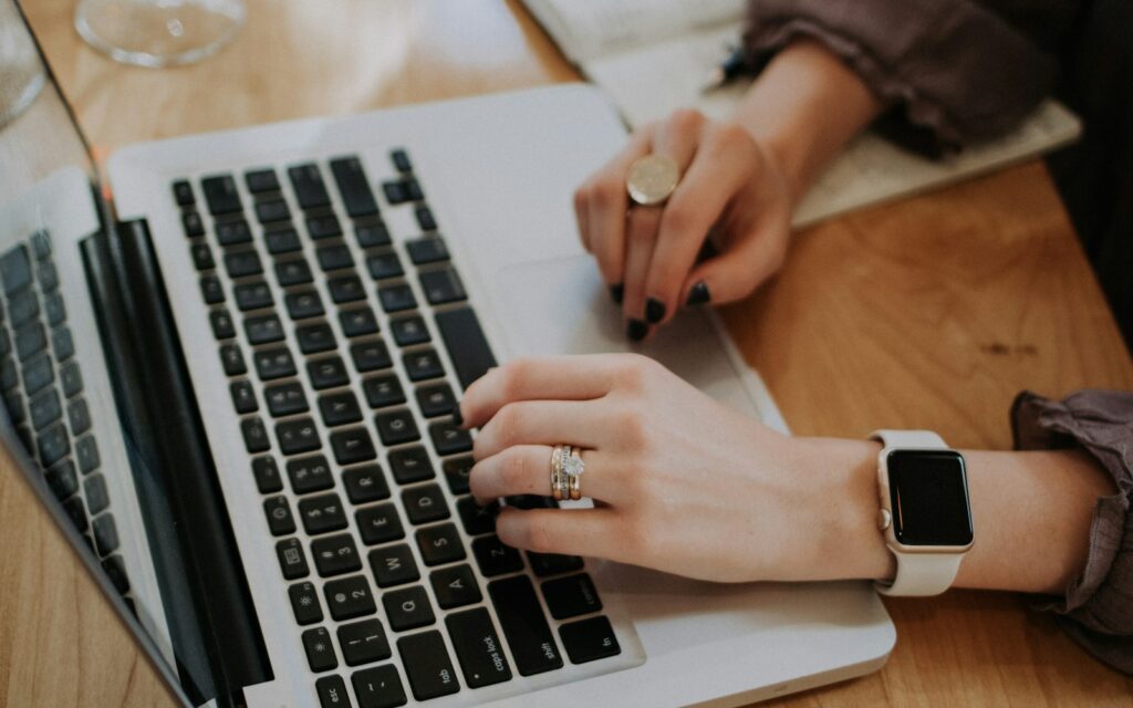Person tippt am Laptop und formuliert Texte für Meta-Title und Description