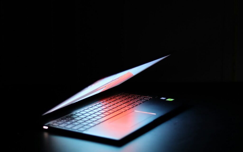 Laptop im dunklen Raum als Sinnbild für Startup-Marketing und die Arbeit am Nebenprojekt nach Feierabend