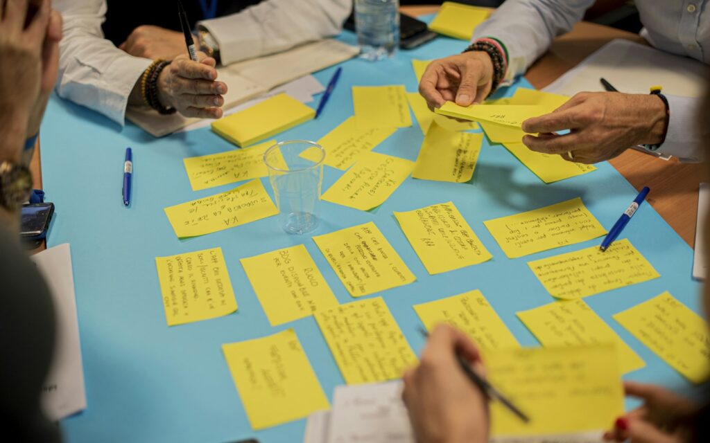 Hand mit gelben Haftnotizen im Workshop, um eine Buyer Persona erstellen zu können