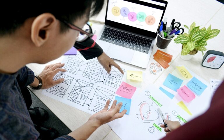 Designer entwirft am Schreibtisch Wireframes mit Call to Action Buttons