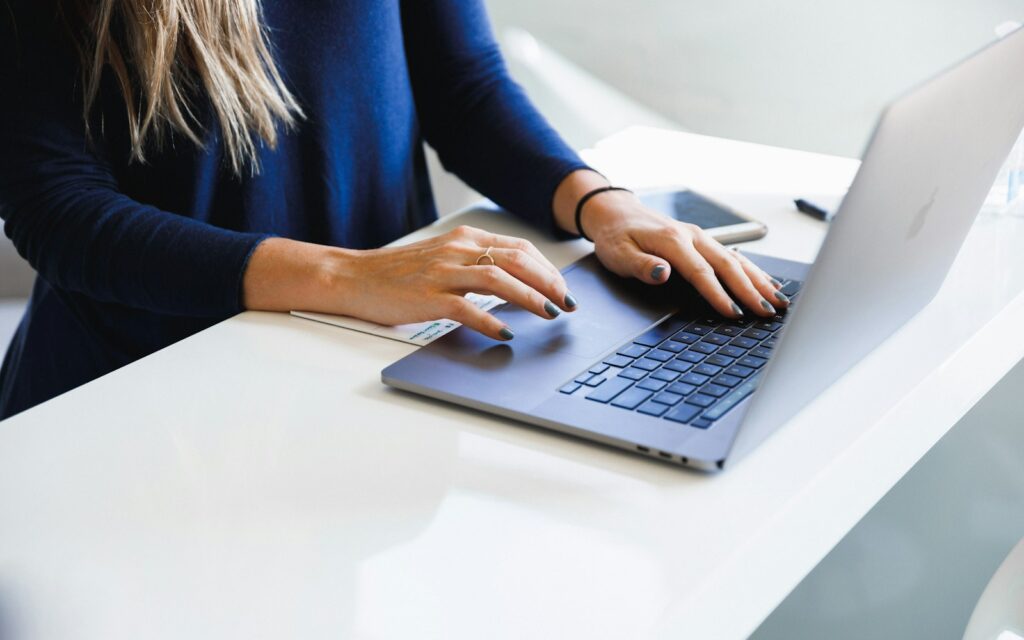 Frau testet am MacBook ChatGPT-Prompts für Marketing-Kampagnen