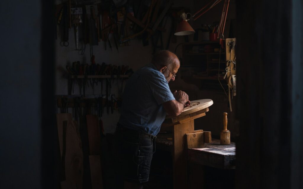Handwerker in seiner Werkstatt, der Termine und Kundenhistorie in einem CRM für Handwerker pflegt