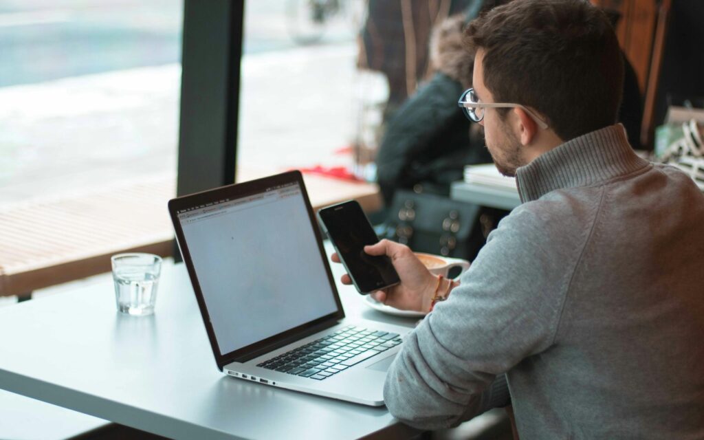 Unternehmer pflegt Kontakte am Laptop im CRM für kleine Unternehmen
