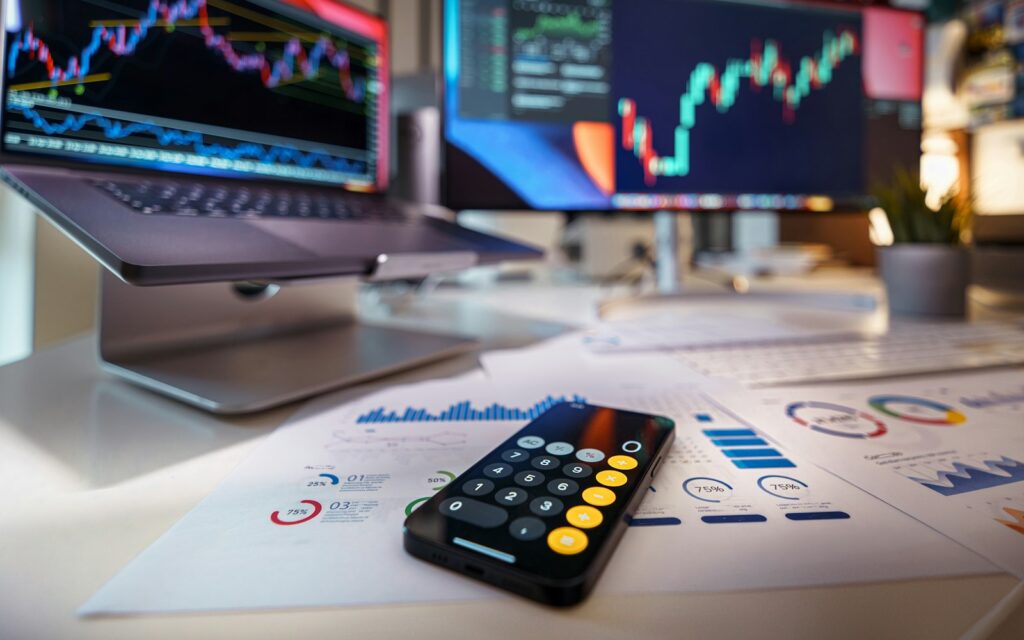 Taschenrechner und Charts am Schreibtisch, um Customer Acquisition Cost berechnen zu können