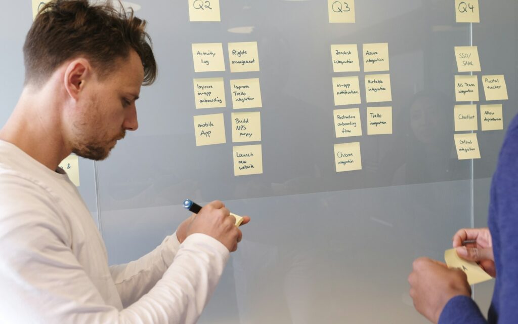 Person plant an einer Whiteboard-Wand den Go-to-Market-Fahrplan für die ersten 90 Tage