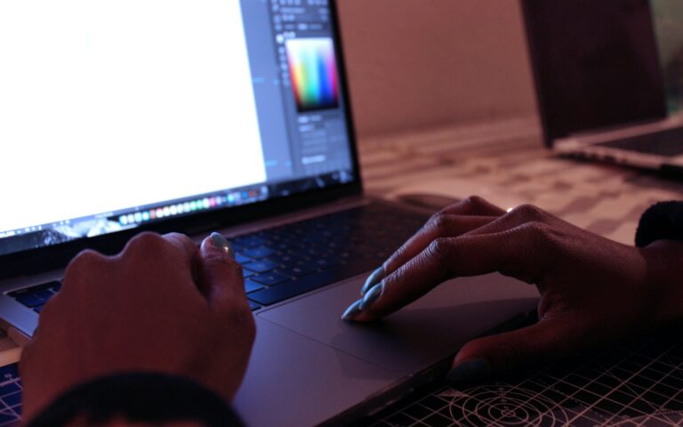 Designer am Laptop prüft, ob er KI-Bilder kommerziell nutzen darf