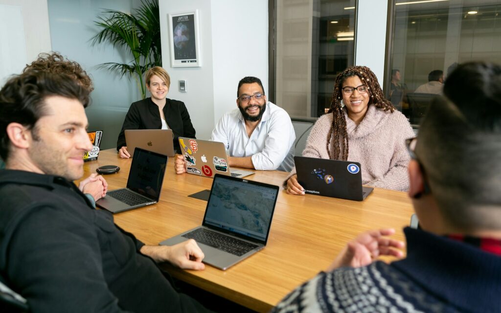Mitarbeitende testen in einem Workshop KI-Tools für Unternehmen am Laptop