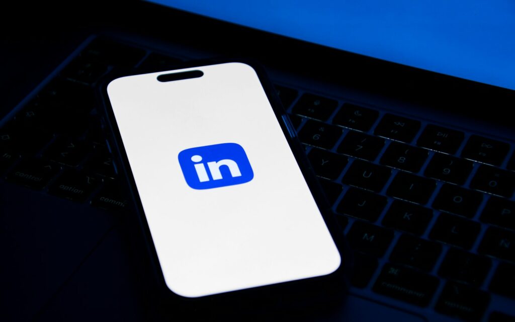 Smartphone auf Laptop als Vorschau zum LinkedIn-Post formatieren
