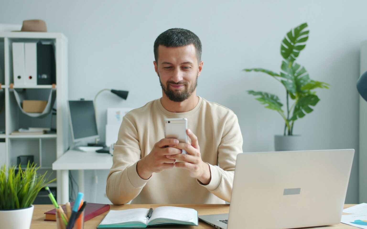 Mann prüft auf dem Smartphone die Reaktionen zu passenden LinkedIn Posting-Zeiten