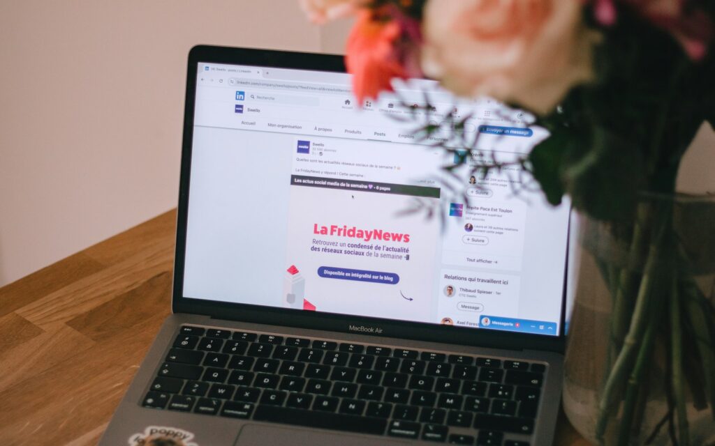 Laptop auf Holztisch zum Planen der LinkedIn Posting-Zeiten im Redaktionsplan