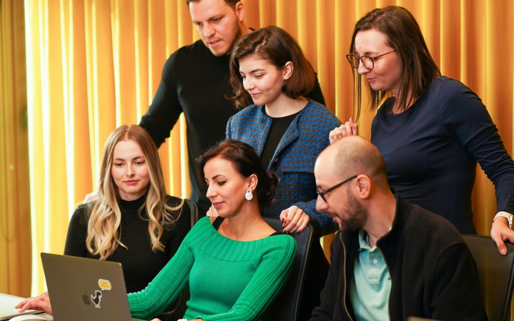 Team arbeitet am Laptop gemeinsam an der Markenbotschaft