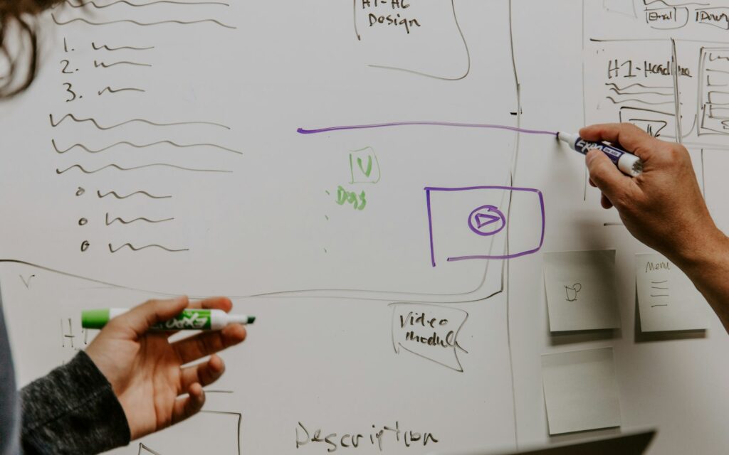 Zwei Personen planen den Marketing-Mix 7P an einem Whiteboard