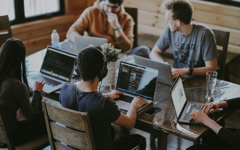 Team arbeitet gemeinsam an Laptops an einem Marketingprojekt