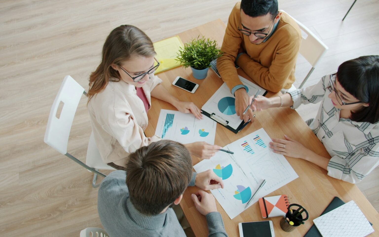 Startup-Team wertet am Tisch Diagramme aus, um den Product-Market-Fit messen zu können