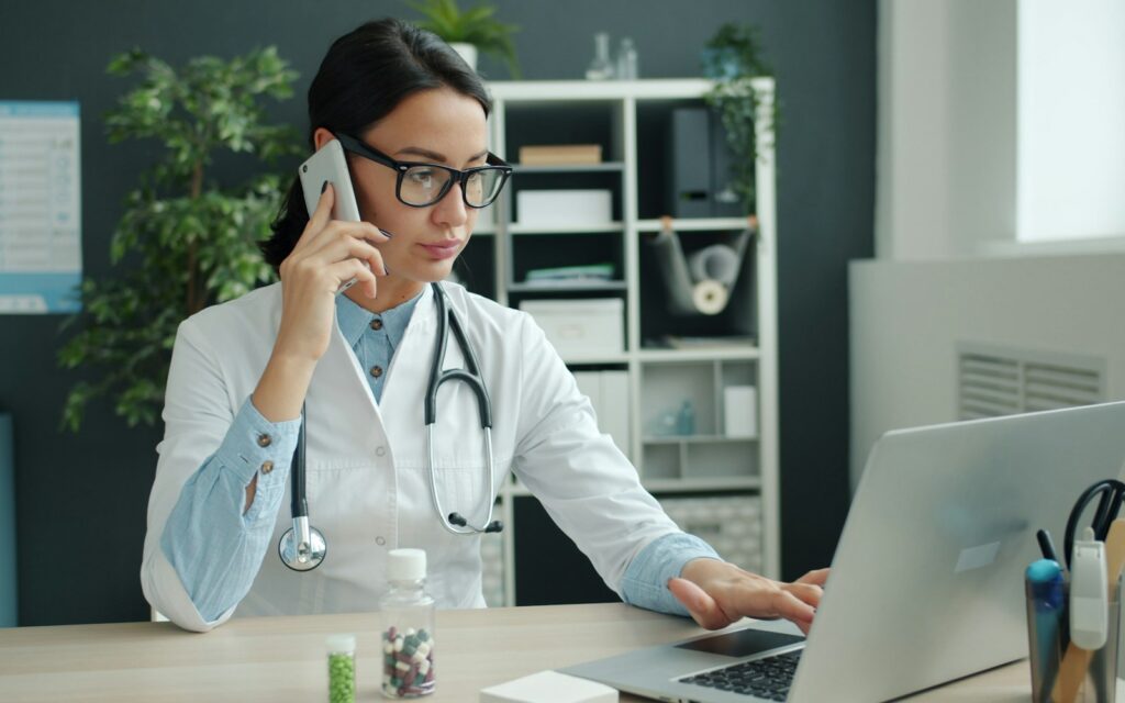 Arzt arbeitet am Laptop an SEO für Ärzte in seiner Praxis