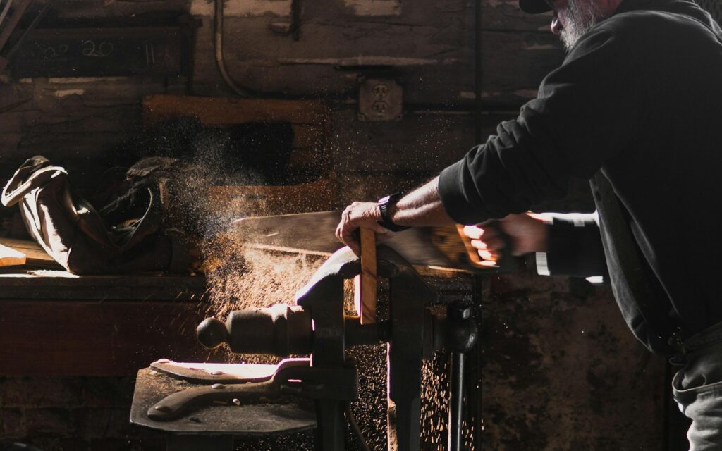 Handwerker beim Sägen in der Werkstatt als Motiv für SEO für Handwerker