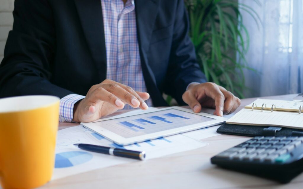 Person im Anzug hält ein Tablet mit Finanzdaten zur Startup-Bewertung