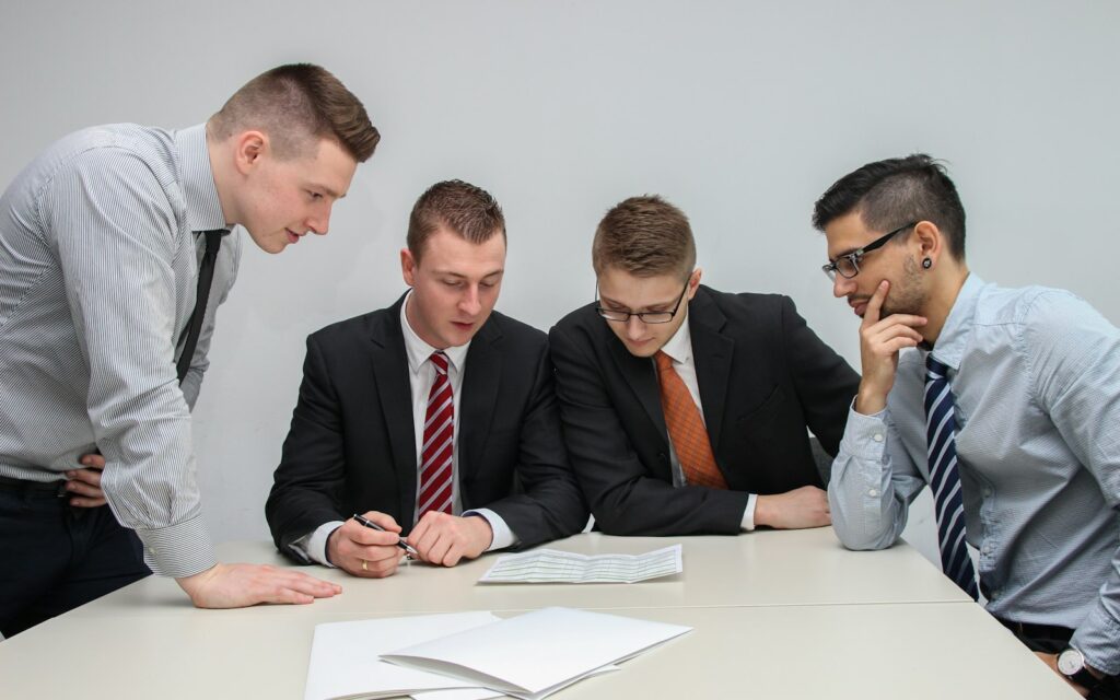Vier Gründer prüfen Unterlagen für einen Antrag auf Startup-Förderung