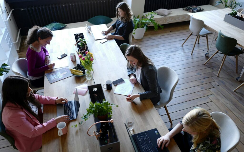 Gründerinnen planen am Holztisch die nächsten Schritte beim Startup gründen