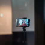 Smartphone auf Stativ filmt eine Person für Videos zu TikTok-Trends