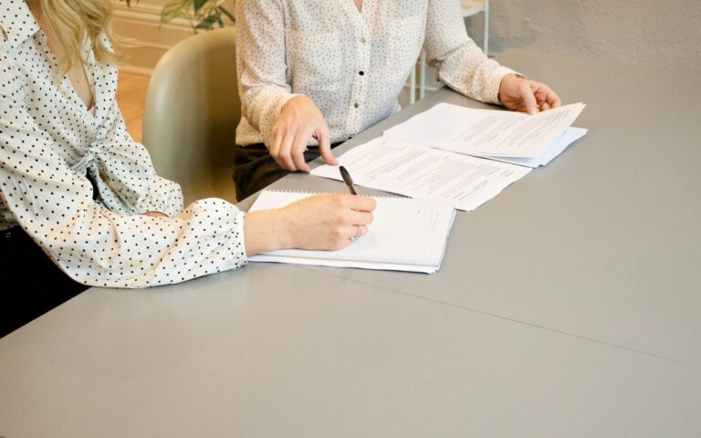 Gründerinnen unterschreiben Gründungsunterlagen nach der Entscheidung UG oder GmbH