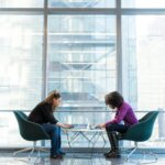 Zwei Frauen besprechen am Laptop, was es kostet, eine Website erstellen lassen zu wollen