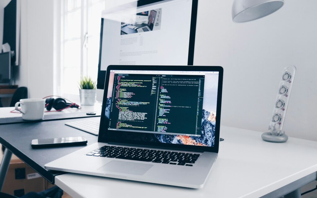 Laptop mit Code auf dem Schreibtisch, wenn Unternehmen eine Website erstellen lassen