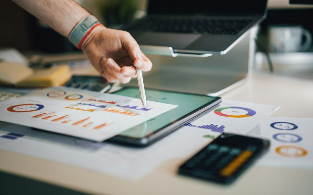 Person analysiert Diagramme auf einem Tablet zur Auswertung von SEO bei Google